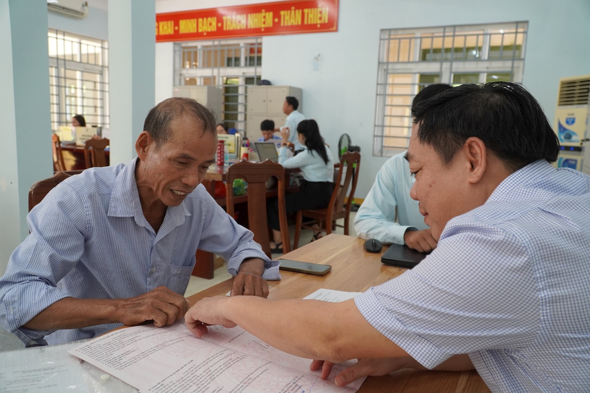 Bí thư Đảng ủy, Chủ tịch HĐND phường Quảng Phú Bùi Ngọc Ảnh (bên phải) tư vấn cho hộ ông Nguyễn Ngọc Thủy trong việc lập thủ tục hồ sơ chuyển mục đích sử dụng đất sáng 5/8. Ảnh: N.ĐOAN
