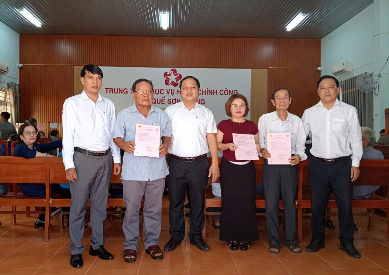 Lãnh đạo xã Quế Sơn Trung trao Giấy chứng nhận quyền sử dụng đất, quyền sở hữu tài sản gắn liền với đất lần đầu cho 3 hộ dân trên địa bàn. Ảnh: DUY THÁI