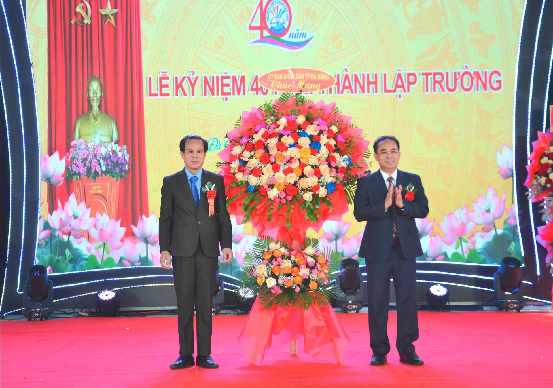 Đồng chí Trần Anh Tuấn (bên phải) tặng lẵng hoa của UBND TP.Đà Nẵng chúc mừng nhà trường. Ảnh: CÔNG TÚ