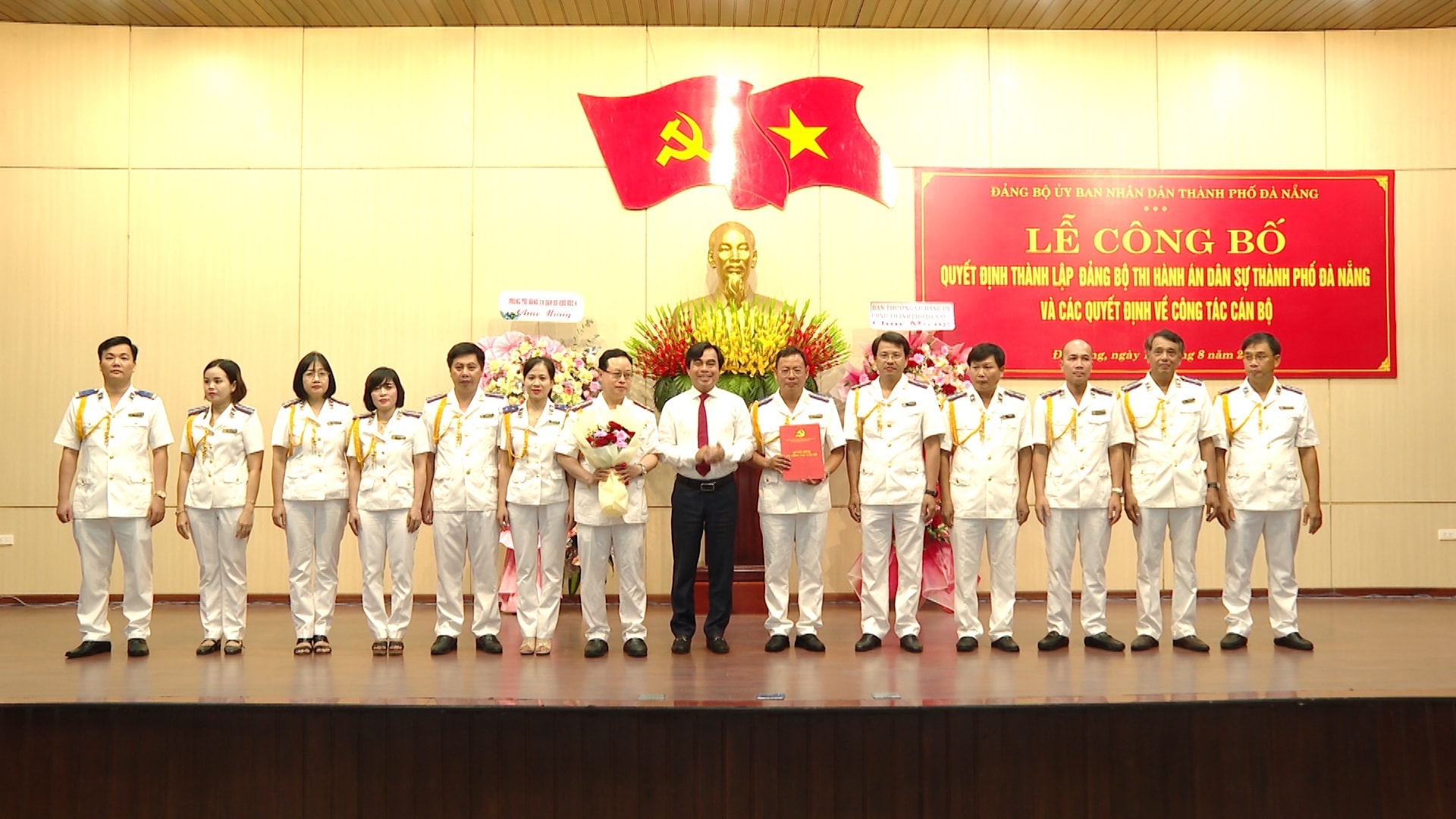 Phó Bí thư Đảng ủy UBND thành phố Tô Văn Hùng (thứ 7 từ phải qua) trao quyết định và tặng hoa chúc mừng Ban Chấp hành Đảng bộ Thi hành án dân sự thành phố Đà Nẵng. Ảnh HN