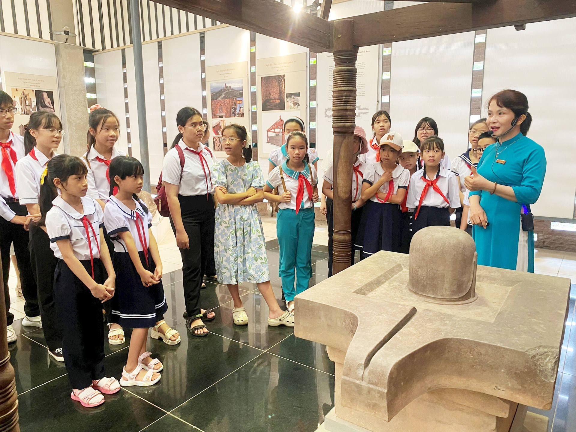 Tham gia chương trình giáo dục di sản, học sinh được nghe thuyết minh về các hiện vật văn hóa Chăm tại Khu đền tháp Mỹ Sơn. Ảnh: VĨNH LỘC
