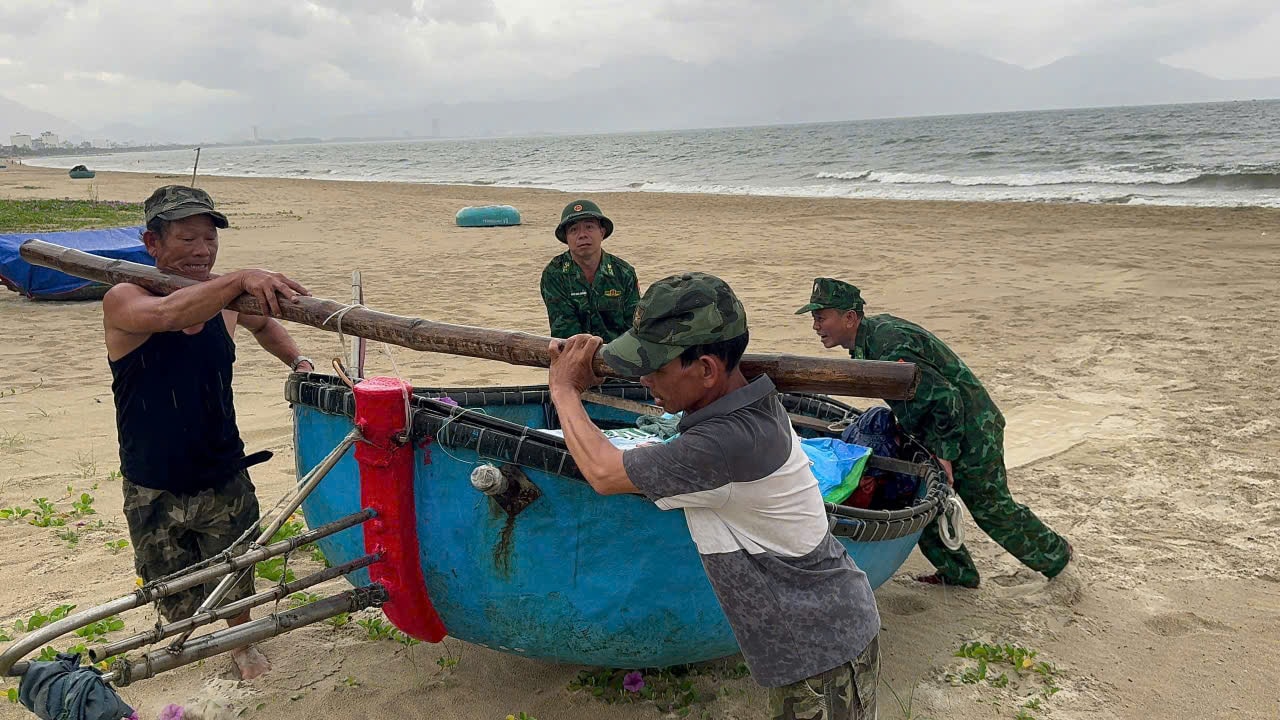 Cán bộ Đồn Biên phòng Phú Lộc giúp dân kéo thúng vào nơi an toàn. Ảnh: BIÊN PHÒNG
