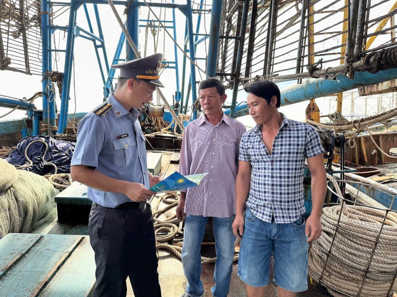 Gặp gỡ, tuyên truyền và phát tờ rơi chống khai thác IUU cho ngư dân. Ảnh: TẤN HIỆP