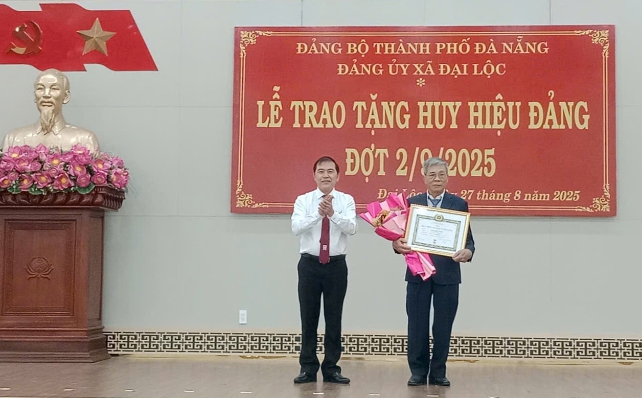 Phó Trưởng ban Thường trực Ban Tổ chức Thành ủy Nguyễn Đức Nam trao Huy hiệu Đảng cho đảng viên thuộc Đảng bộ xã Đại Lộc. Ảnh: NGUYE