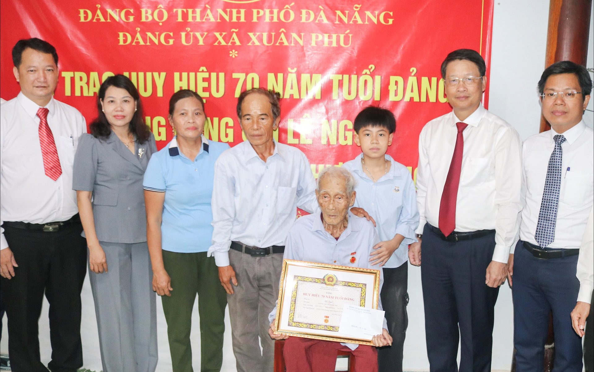 Phó Bí thư Thành ủy Ngô Xuân Thắng (thứ hai, bên phải sang) trao Huy hiệu 70 năm tuổi Đảng cho đảng viên Lê Ngư. Ảnh: BÍCH LIÊN