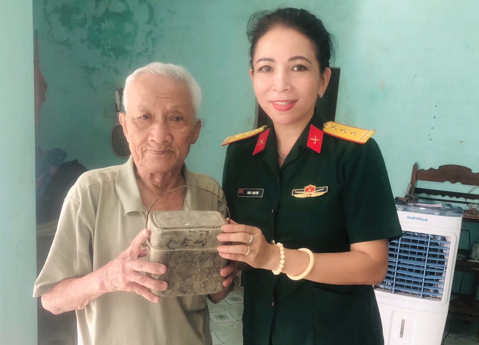 Ông Trương Thọ trao cho Thượng tá Trần Thị Anh Thư, Giám đốc Bảo tàng Quân khu 5 chiếc ăng-gô đựng cơm nuôi bộ đội ngày trước của gia đình. Ảnh: T.Y