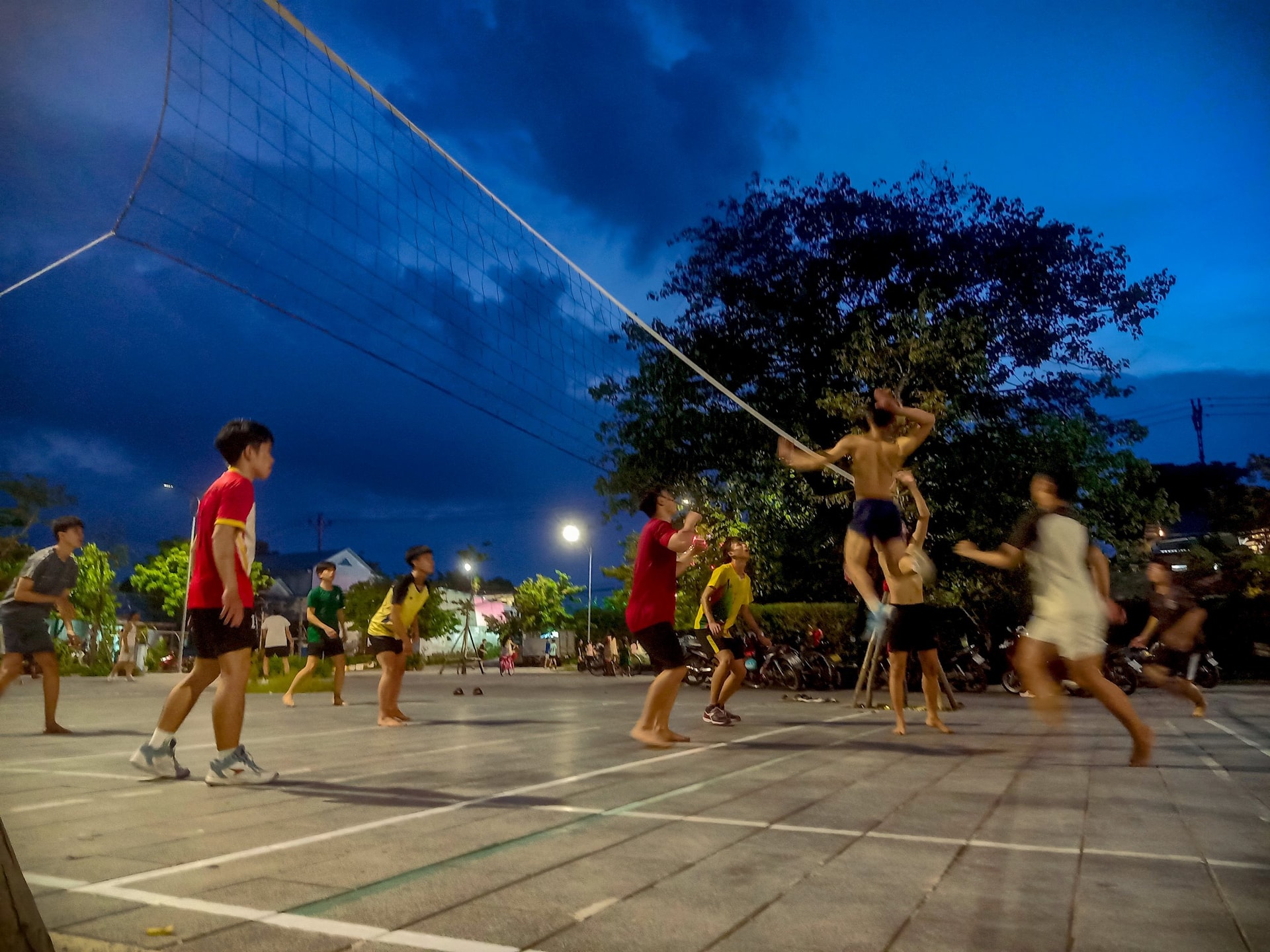 Phố đã lên đèn nhưng sân bóng chuyền vẫn còn đông kín người tập luyện. Ảnh Nguyễn Điện Ngọc