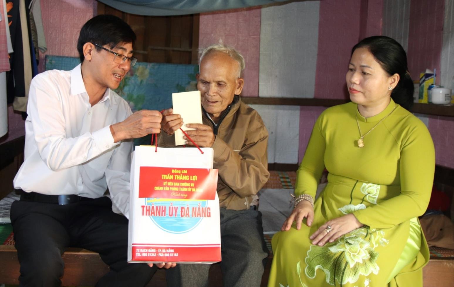 Chánh Văn phòng Thành ủy Trần Thắng Lợi (bên trái) tặng quà cho ông Hiên Ngái. Ảnh: T. HUY