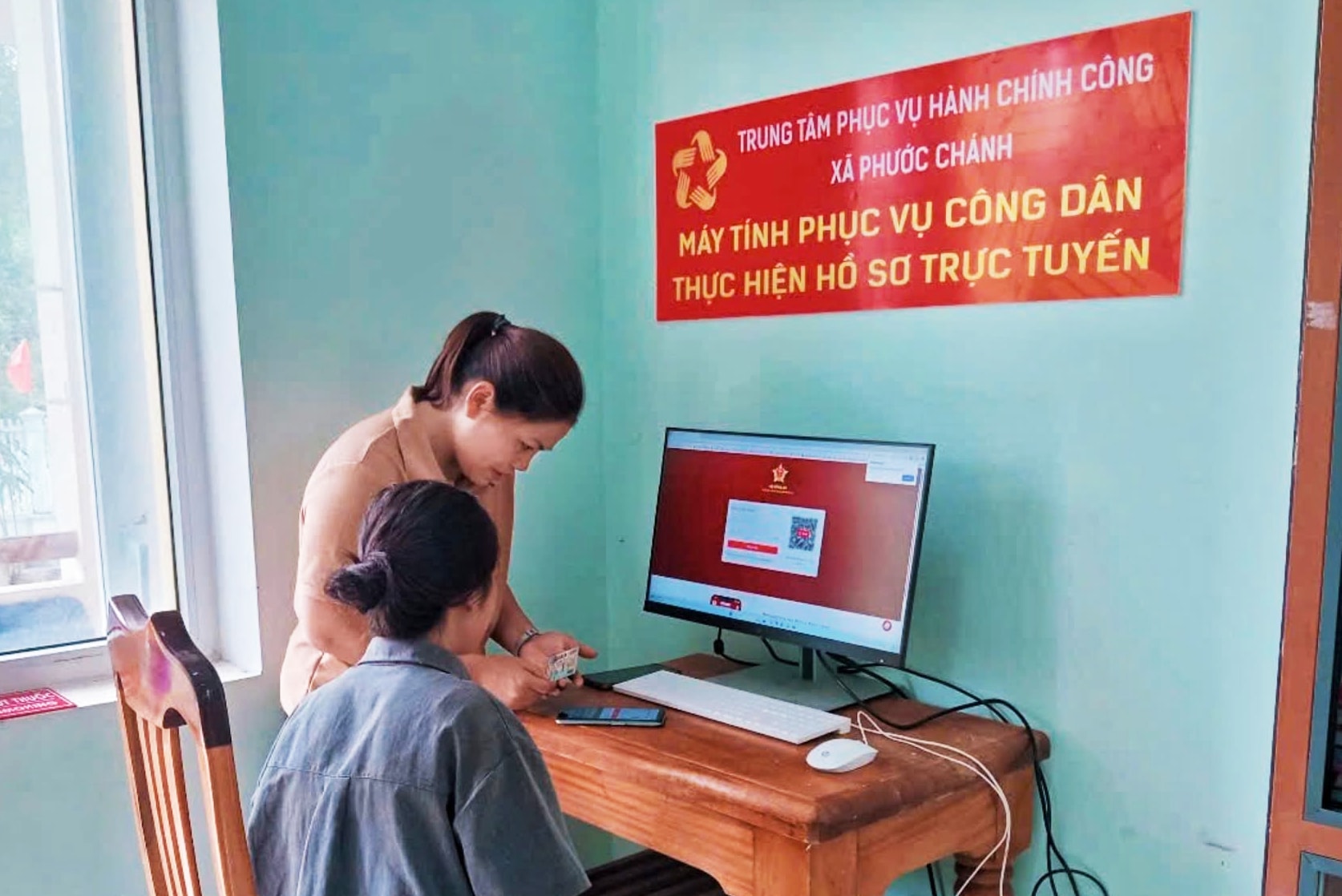 Anh 4 - Can bo Phuoc Chanh hướng dẫn người dân thực hiện thủ tục hành chính thông qua Cổng dịch vụ công trực tuyến.