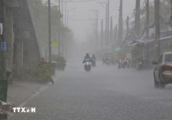 Người dân cần chú ý khi đi ra ngoài trong lúc mưa dông. (Ảnh: Duy Khương/TTXVN) ttxvn-mua-dong-2208.jpg
