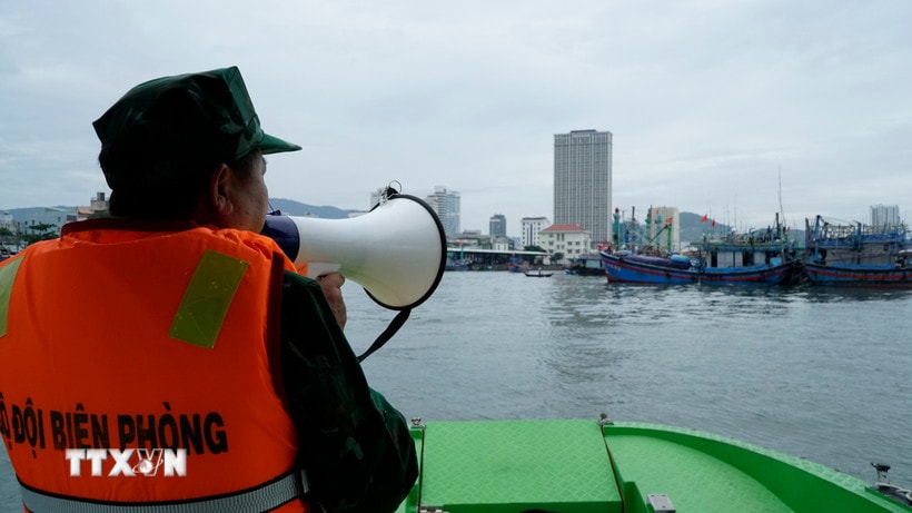 Bộ đội biên phòng thông báo diễn biến của bão số 12 cho ngư dân. (Ảnh: Đình Quân/TTXVN)