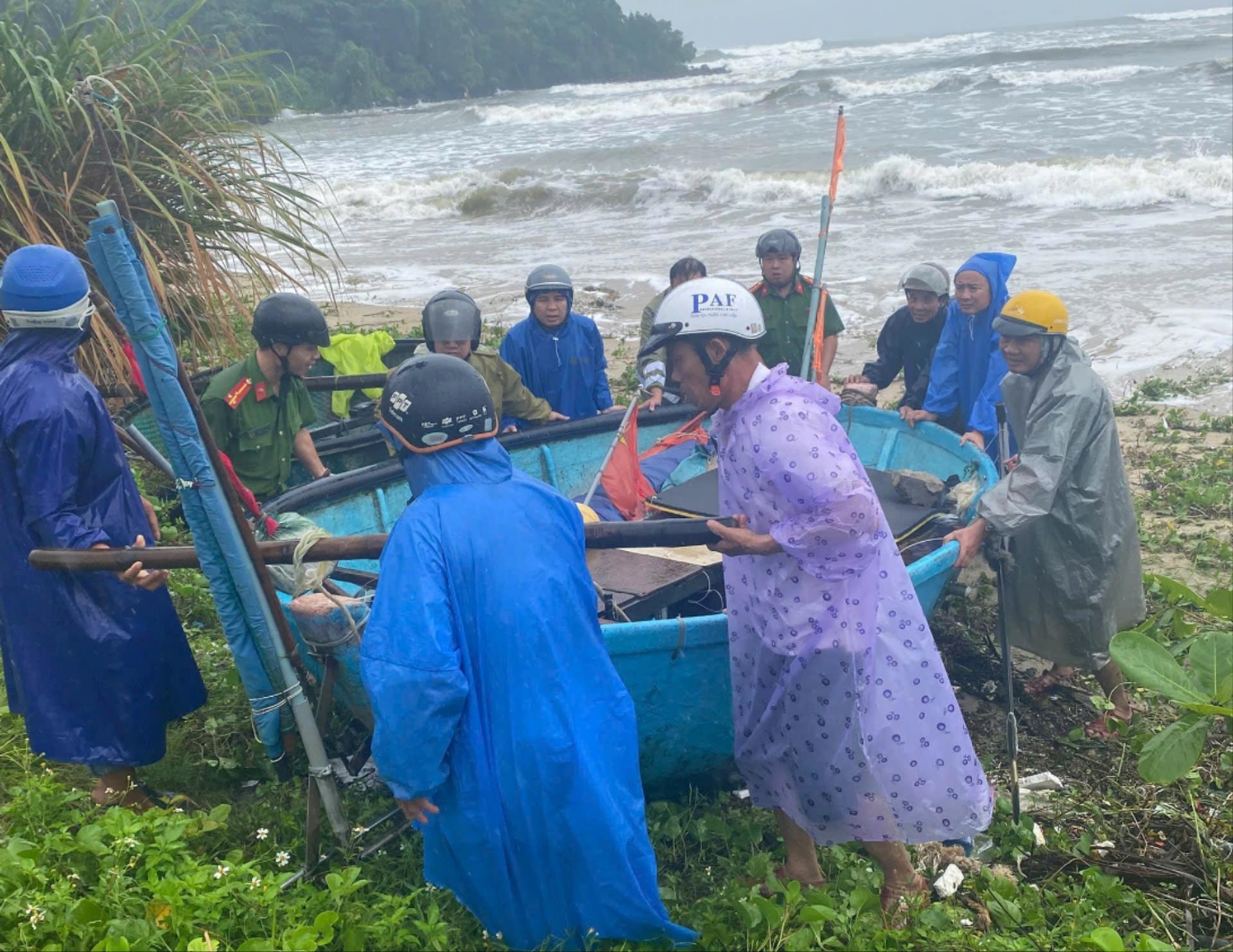 ប៉ូលីសសង្កាត់ Hai Van បានជួយអ្នកនេសាទក្នុងការនាំទូករបស់ពួកគេចូលច្រាំង មុនពេលព្យុះទី 12 បោកបក់មកលើគោក។ រូបថត៖ HOA KHANH