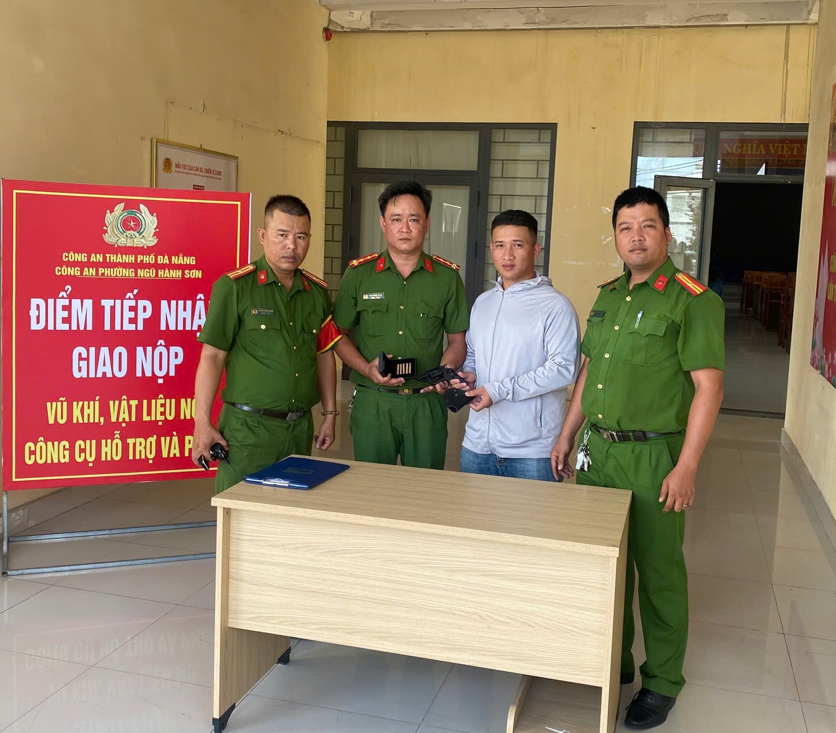 Công an phường Ngũ Hành Sơn tiếp nhận vũ khí, công cụ hỗ trợ do người dân giao nộp. Ảnh LÊ HÙNG