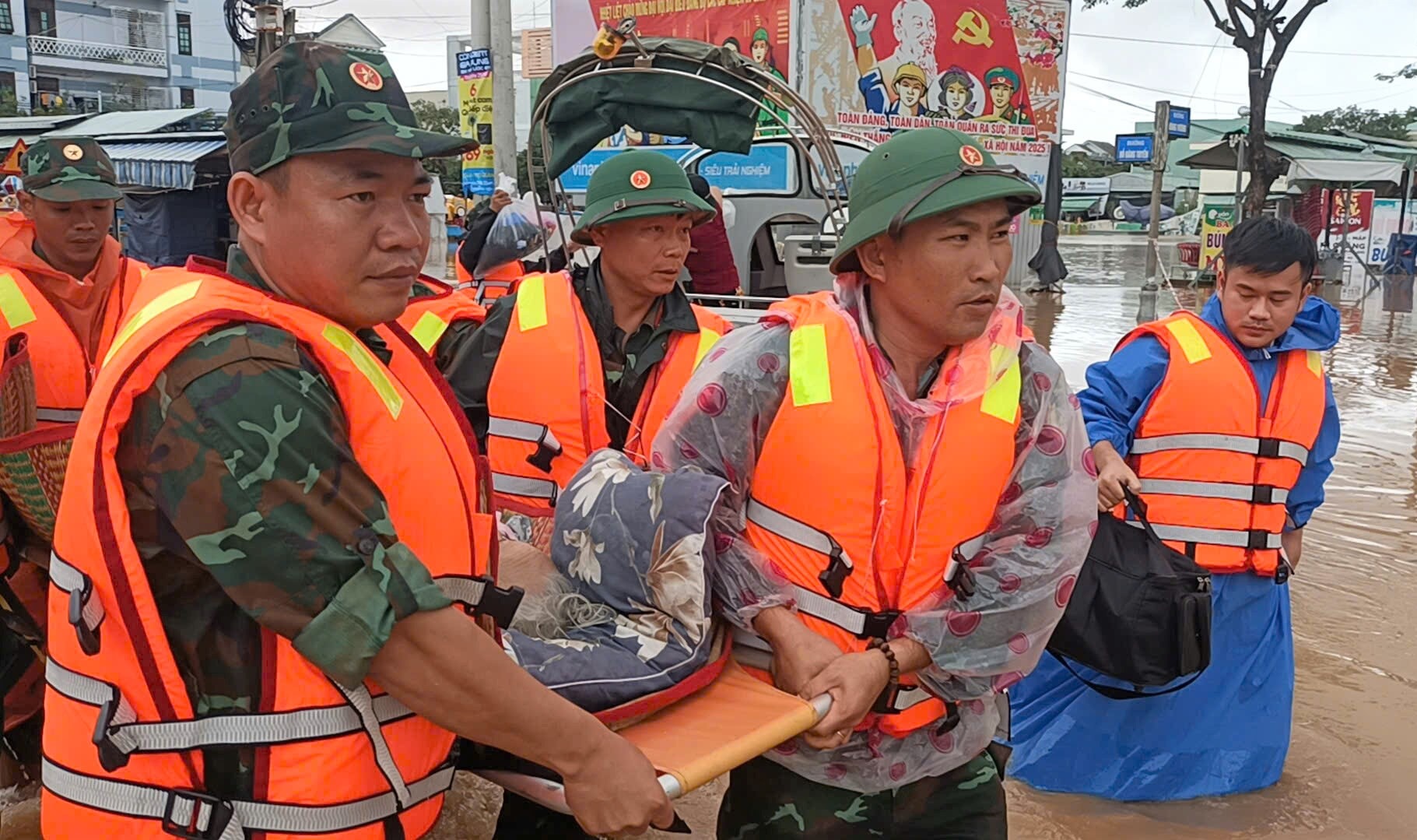 Cán bộ, chiến sĩ Bộ Chỉ huy Quân sự thành phố trung chuyển Mẹ Việt Nam anh hùng Lê Thị Năm ở xã Vu Gia khỏi vùng ngập lụt. Ảnh: BRIU NA