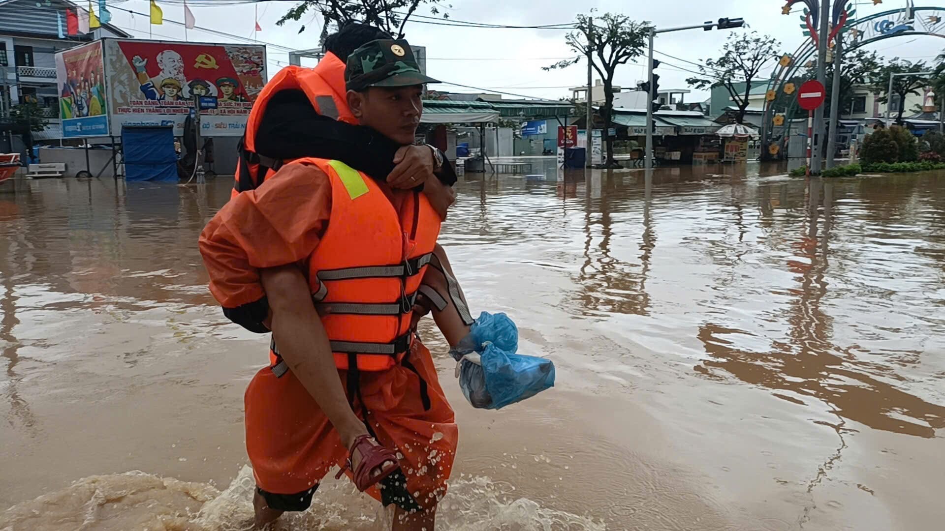 ទាហាន និង​ប្រជាពលរដ្ឋ​ឆ្លង​កាត់​ទឹក​លិច​ទៅ​មន្ទីរពេទ្យ​ដើម្បី​ព្យាបាល។ រូបថត៖ HOA KHANH