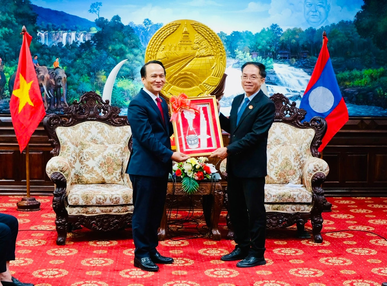 Daovong Phonekeo (R) presents a souvenir to Nguyen Dinh Vinh.