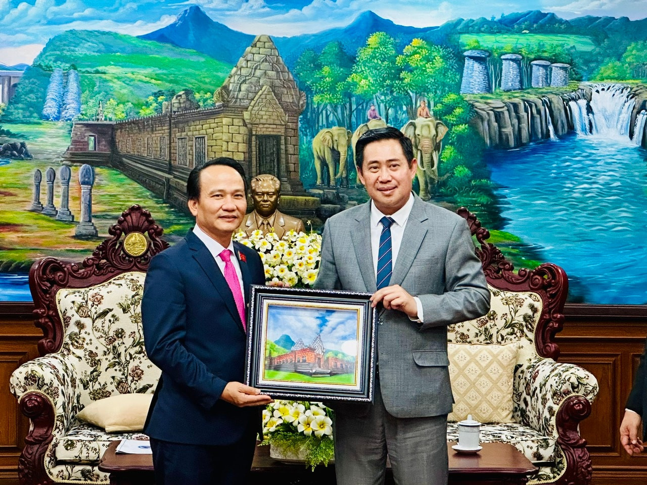 Alounxay Sounnalath (R) presents a souvenir to Nguyen Dinh Vinh.