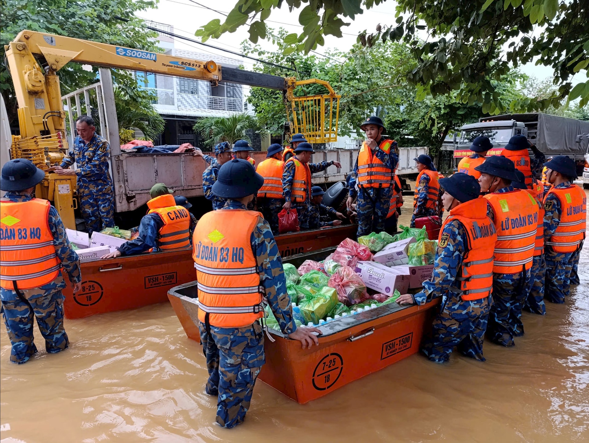 Lương thực, thực phẩm được cán bộ, chiến sĩ Lữ đoàn Công binh 83 cẩn thận đưa lên xuồng máy để đưa đến người dân bị cô lập do mưa lũ. Ảnh: LÊ HÙNG