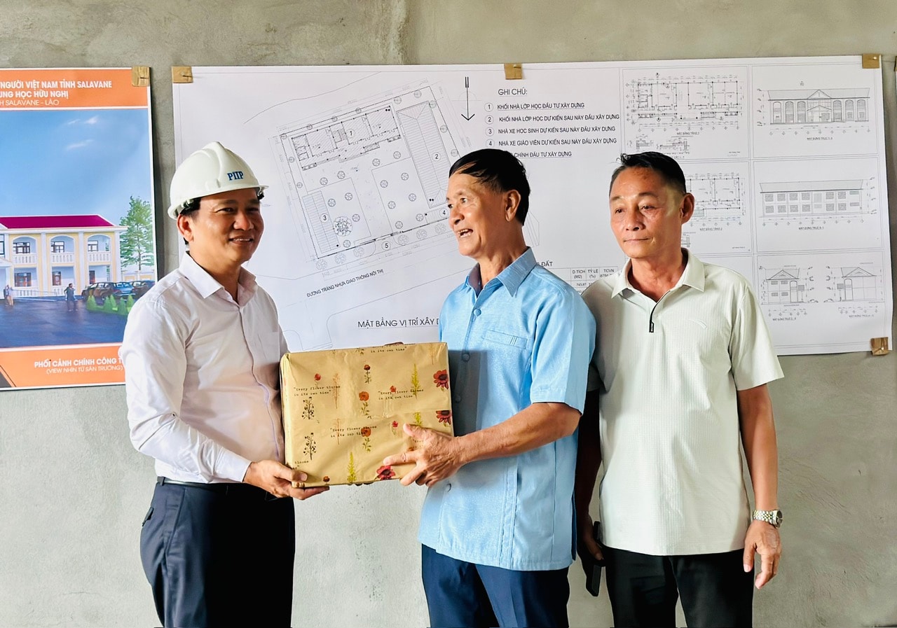 Phó Bí thư Thường trực Thành ủy Nguyễn Đình Vĩnh tặng quà đại diện Hội người Việt Nam tại tỉnh Salavane, Lào. Ảnh Xuân Hiếu