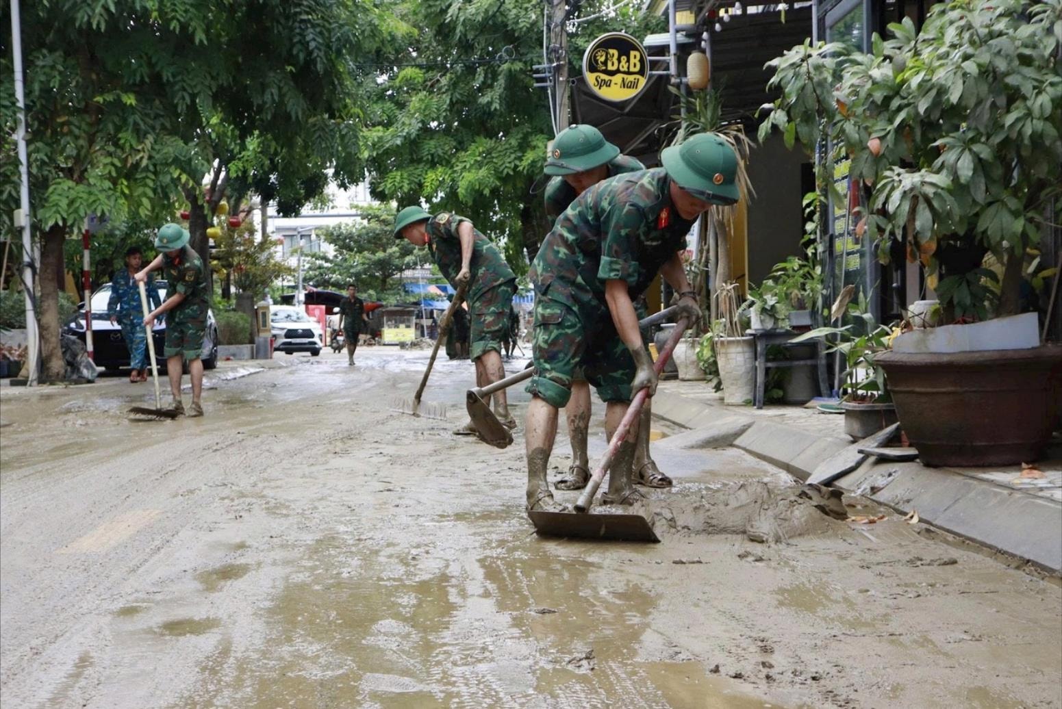 Lực lượng vũ trang Quân khu 5 giúp dân dọn dẹp bùn đất sau đợt lũ lụt tháng 10 vừa qua. Ảnh: MINH THY