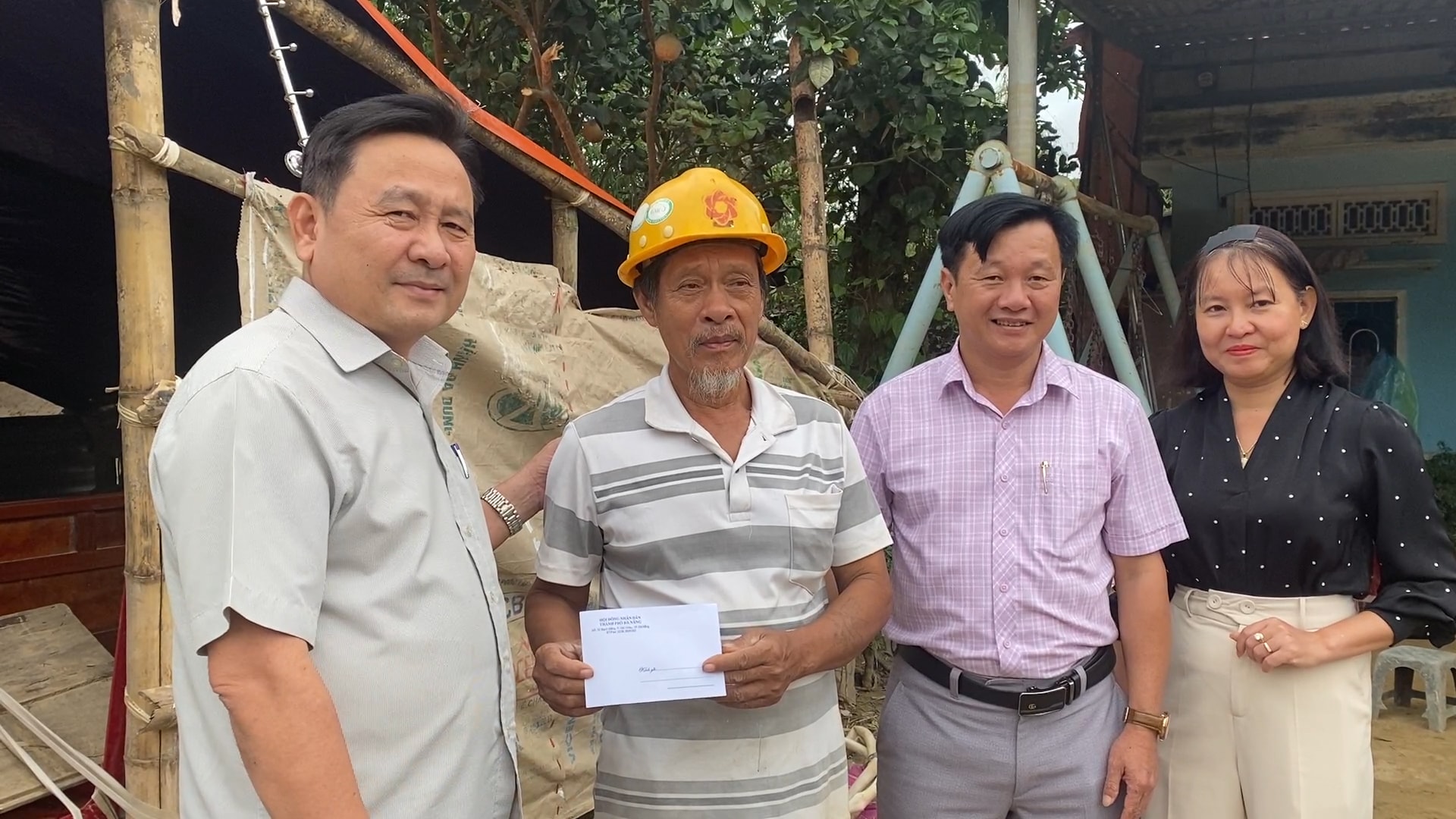 Nestleder i byrådet, Nguyen Cong Thanh (til venstre), og lederne i Nong Son kommune overrakte gaver for å oppmuntre Tran Nams familie i landsbyen Nong Son, som led store tap i den nylige flommen. Foto: THU PHUONG