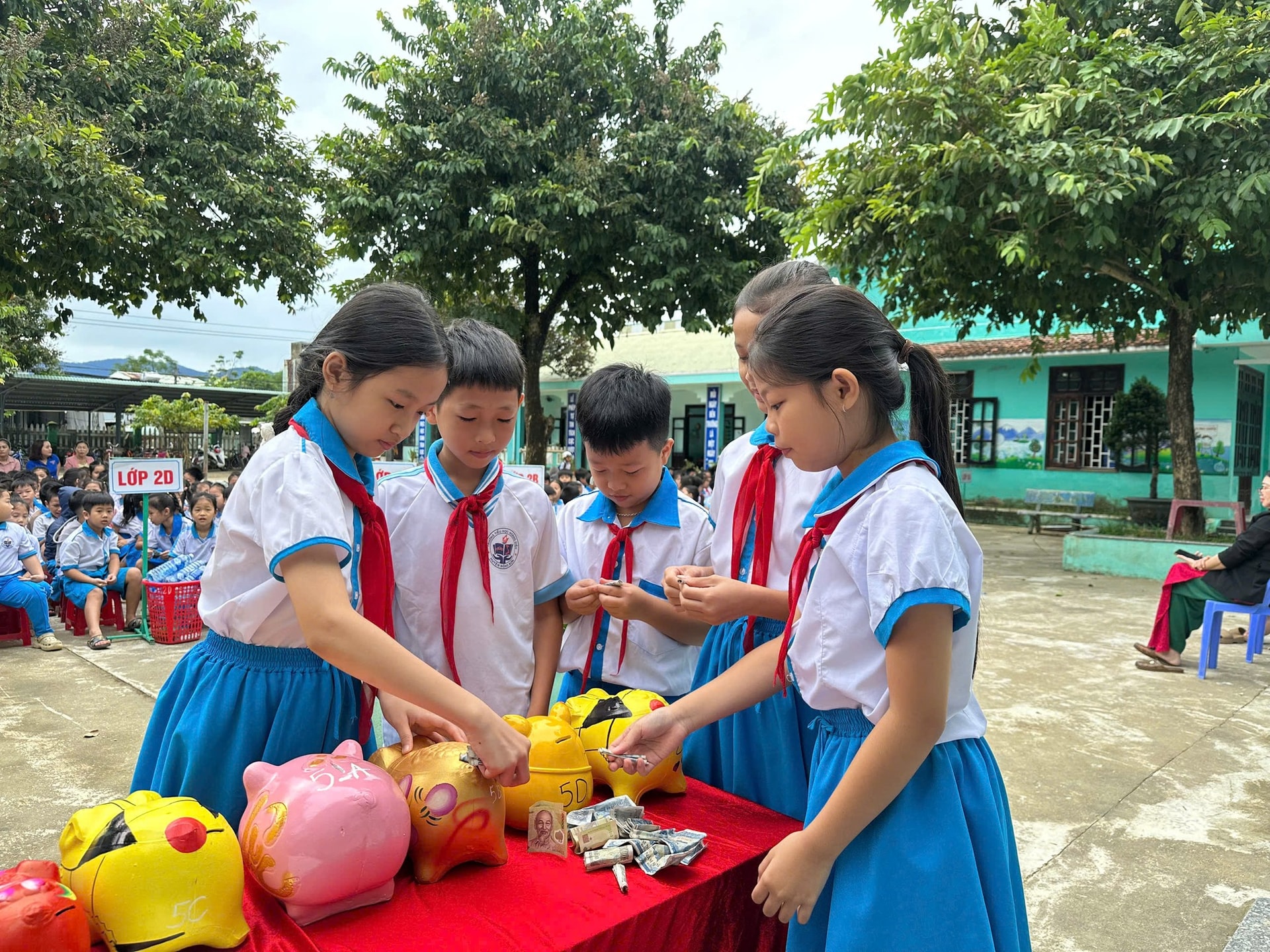 Các bạn học sinh Trường TH Hoàng Diệu bỏ heo đất giúp bạn. Ảnh: THU PHƯƠNG