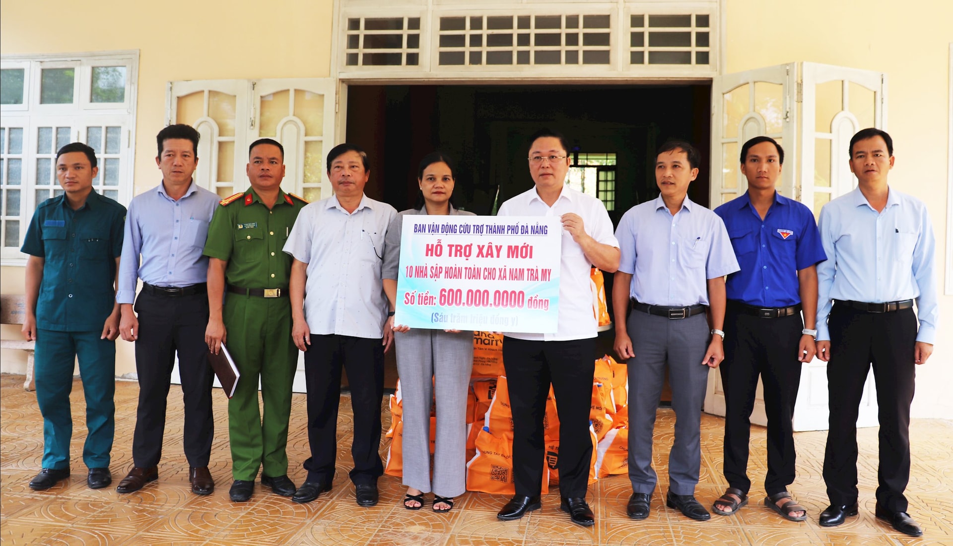 Chủ tịch Ủy ban MTTQ Việt Nam thành phố Lê Trí Thanh (thứ 4 từ phải qua) 600 triệu đồng hỗ trợ xây mới cho 10 nhà dân bị thiệt hại hoàn toàn do mưa lũ, sạt lở của xã Nam Trà My. Ảnh: ĐẮC MẠNH