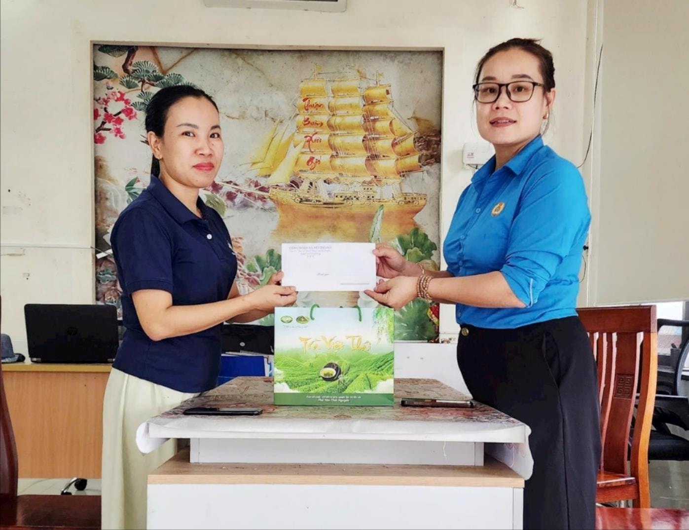 Bà Trần Thị Diệu Phúc, Chủ tịch Công đoàn xã Núi Thành (bên phải) trao quà hỗ trợ Công ty Cổ phần Thái Việt Corporation. Ảnh VIẾT TRỌNG
