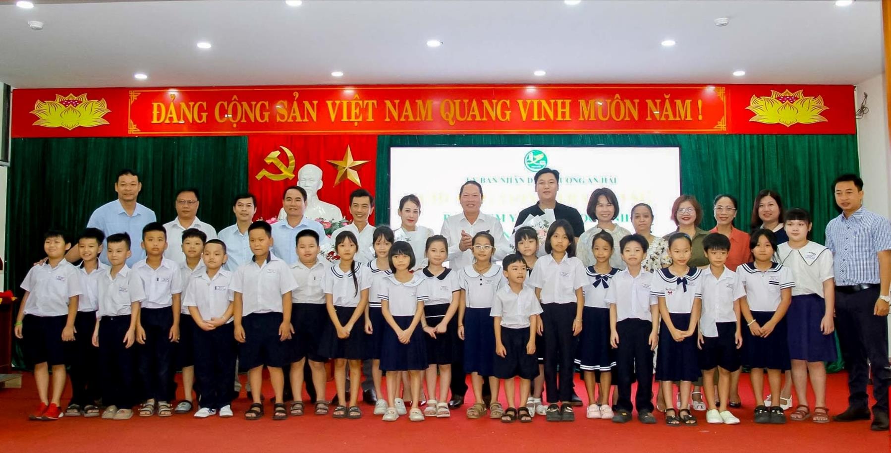 តំណាងគណៈកម្មាធិការប្រជាជនសង្កាត់ An Hai ឧបត្ថម្ភ លោកគ្រូ អ្នកគ្រូ និងសិស្សានុសិស្សក្នុងកម្មវិធីប្រគល់ប័ណ្ណធានារ៉ាប់រងសុខភាព។ រូបថត៖ BAO LAM