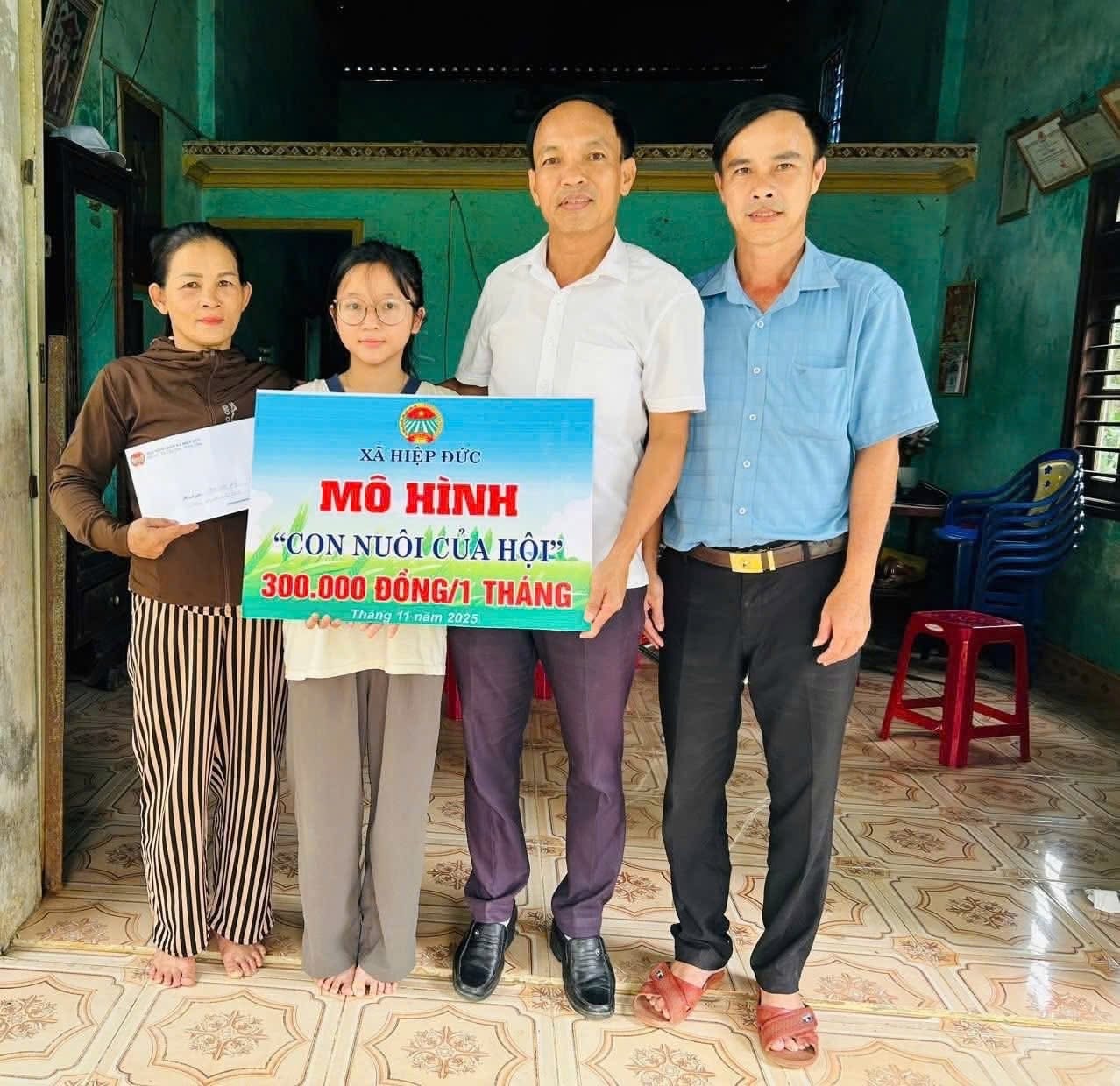 Hội Nông dân xã Hiệp Đức trao bảng tượng trưng hỗ trợ mô hình “Con nuôi của Hội” cho em Cao Thị Anh Thư tại thôn An Nam. Ảnh: V.D