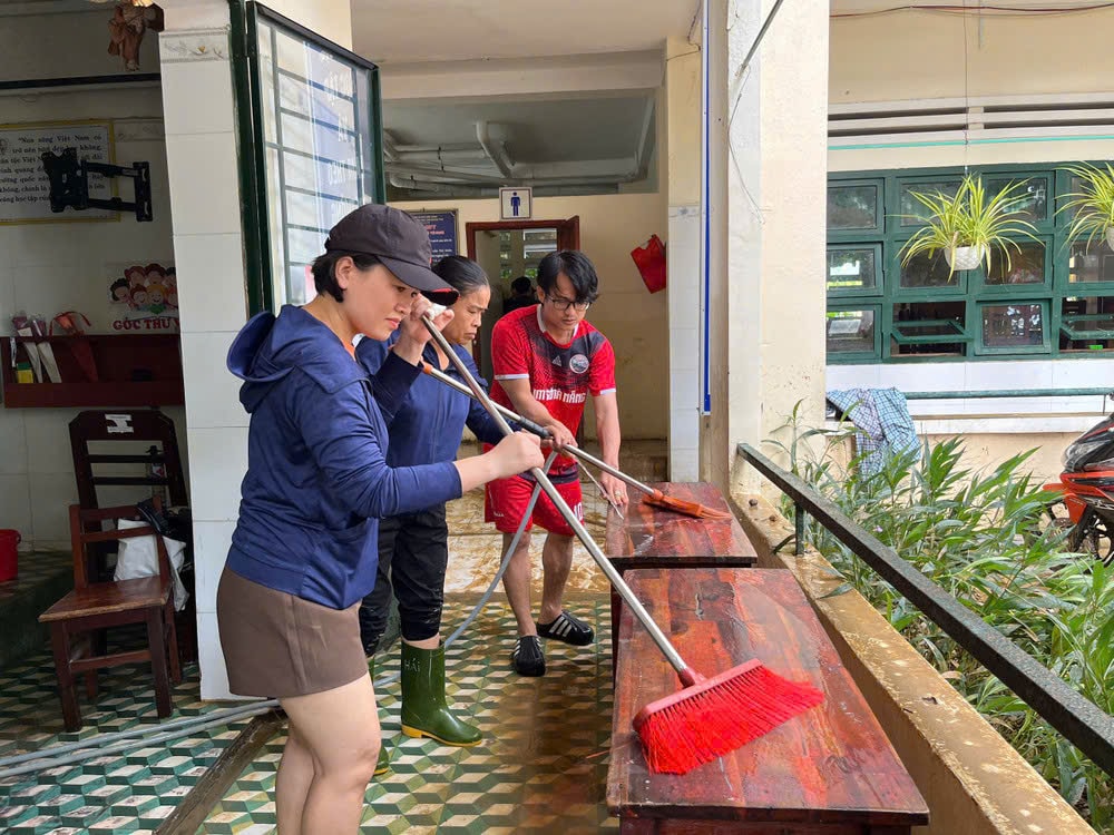 Professores da Escola Primária Lam Quang Thu (Comuna de Hoa Vang) limpam carteiras e cadeiras na sala de aula. Foto: LE HUNG