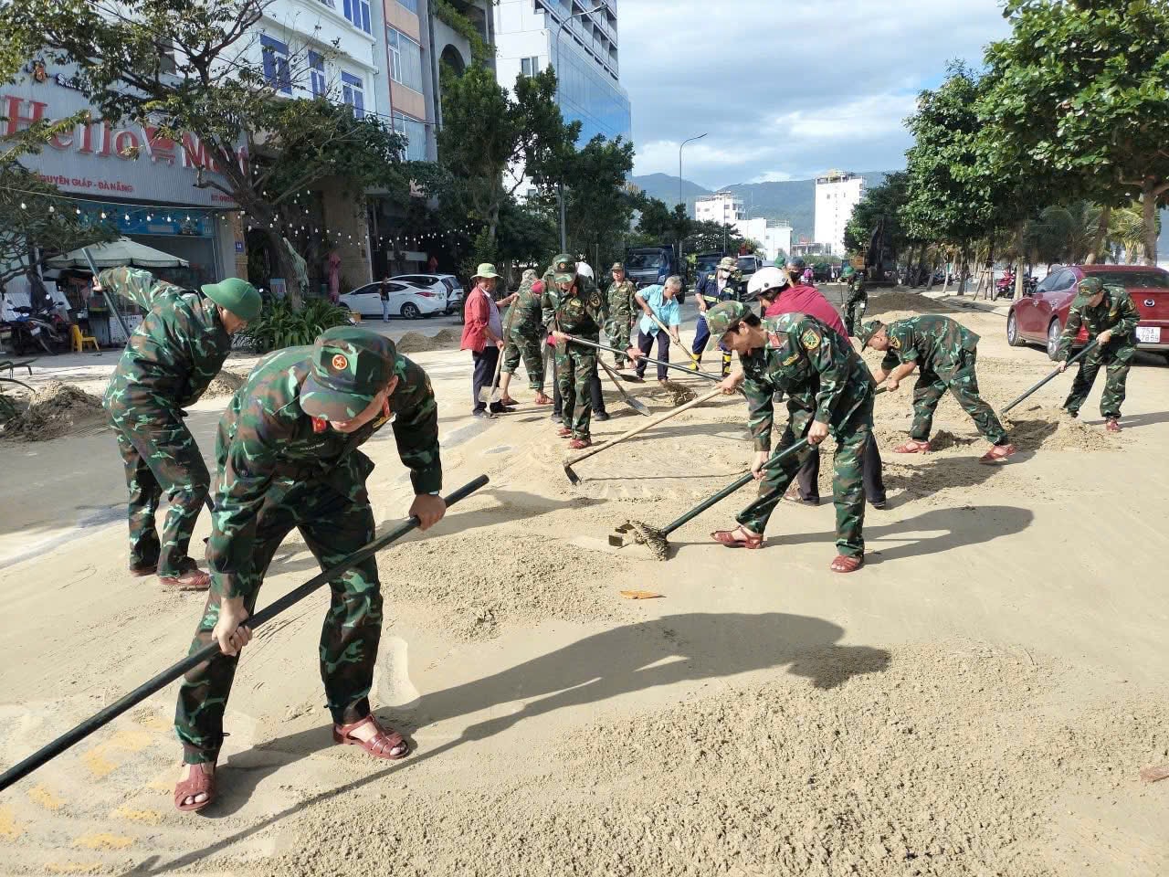 Các chiến sĩ hỗ trợ người dân dọn dẹp trên tuyến đường biển Võ Nguyễn Giáp. Ảnh: PV