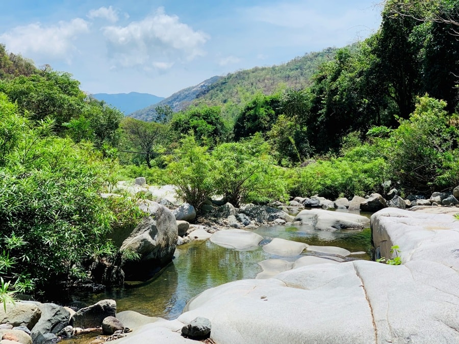 Vẻ đẹp hoang sơ của suối Lồ Ồ với dòng nước trong vắt chảy qua các tảng đá.