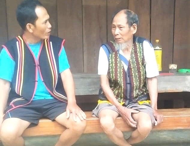 Già làng, đảng viên kỳ cựu người Co, Trần Ngọc Liên (phải) làng suối Riêng sẵn sàng nhờ con cháu hỗ trợ khi áp dụng, sử dụng sổ tay đảng viên điện tử. Ảnh: BÌNH MINH.