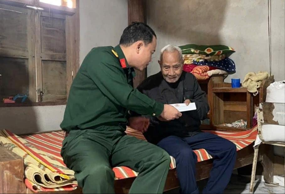 Đại tá Trần Hữu Ích trao quà cho người dân có hoàn cảnh khó khăn. Ảnh: BÍCH HẠNH