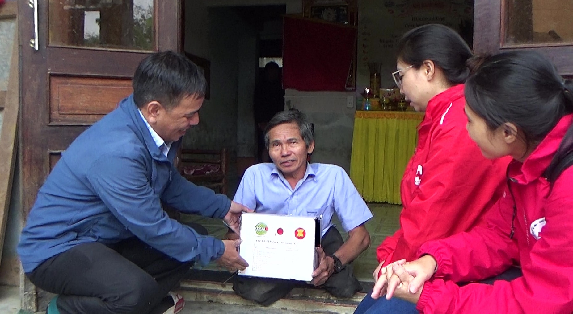 Đại diện Hội Chữ thập đỏ thành phố Đà Nẵng và chính quyền xã Hòa Tiến trao quà hỗ trợ cho người dân bị ảnh hưởng thiên tai. Ảnh: XUÂN SƠN
