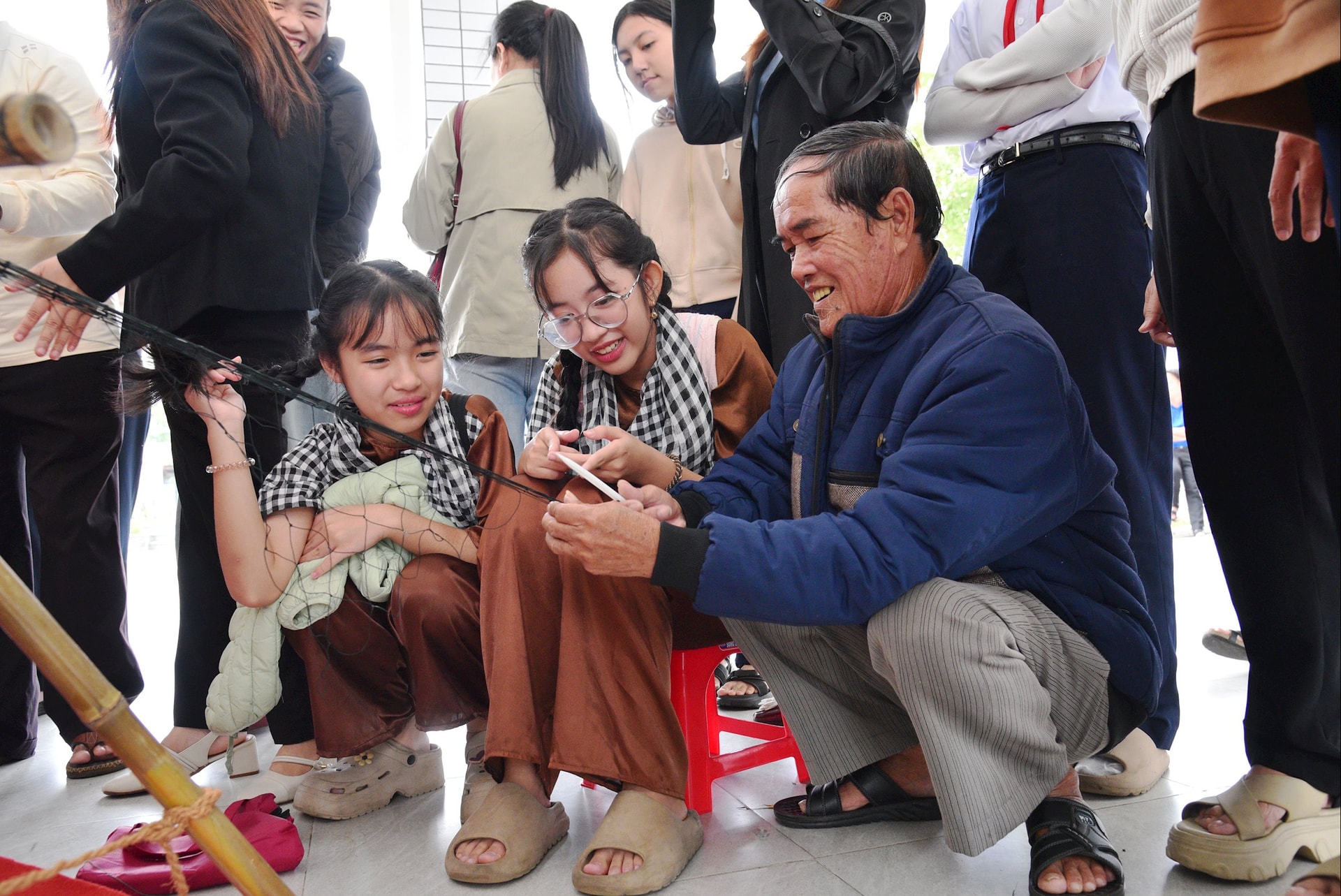 صيادون من منطقة سون ترا الساحلية يرشدون الطلاب في نسج الشباك في مهرجان 