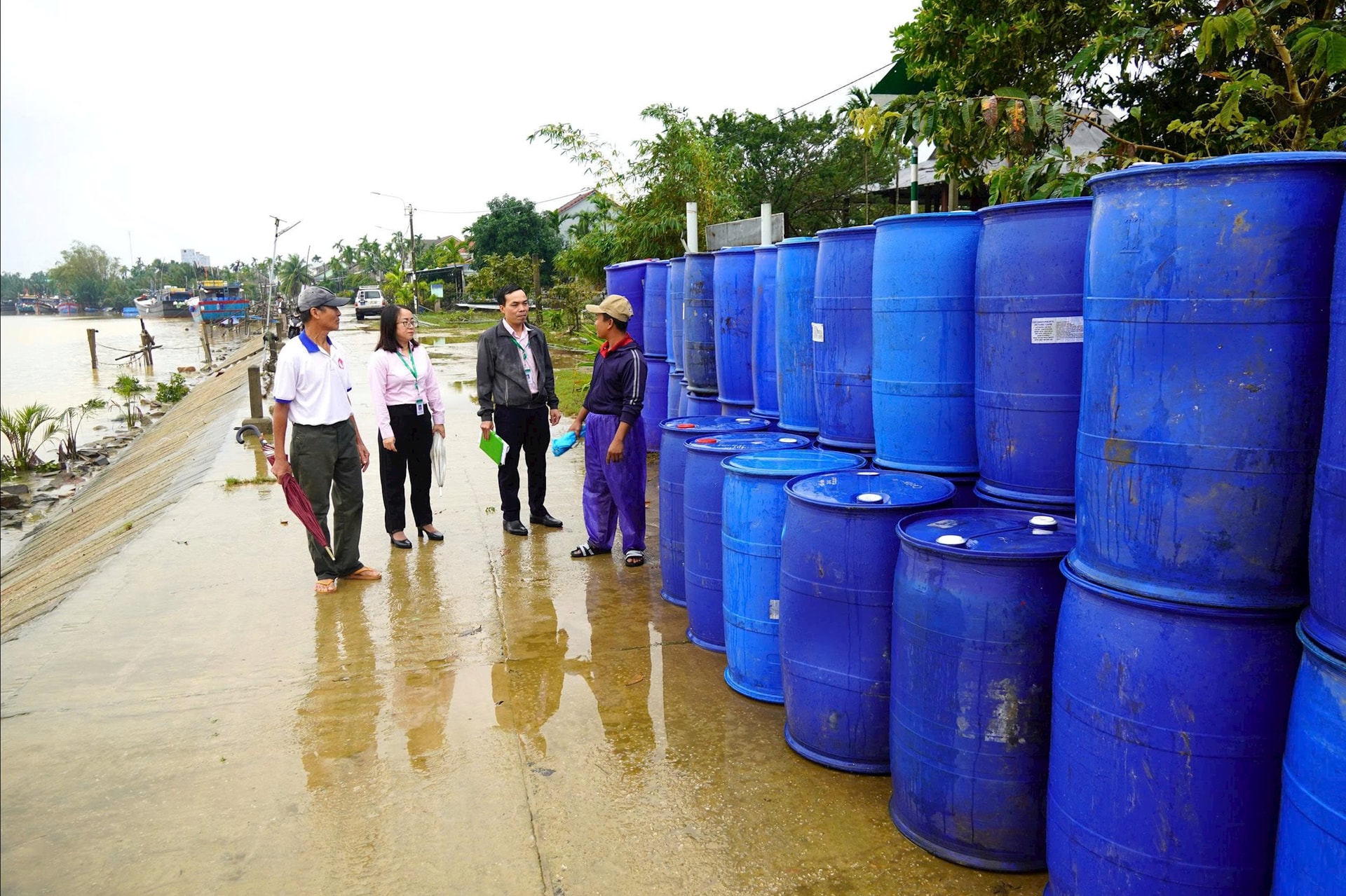 Mr. Lien (first on the right) received capital support to buy barrels to build new fish rafts. Photo: CHAU THANH
