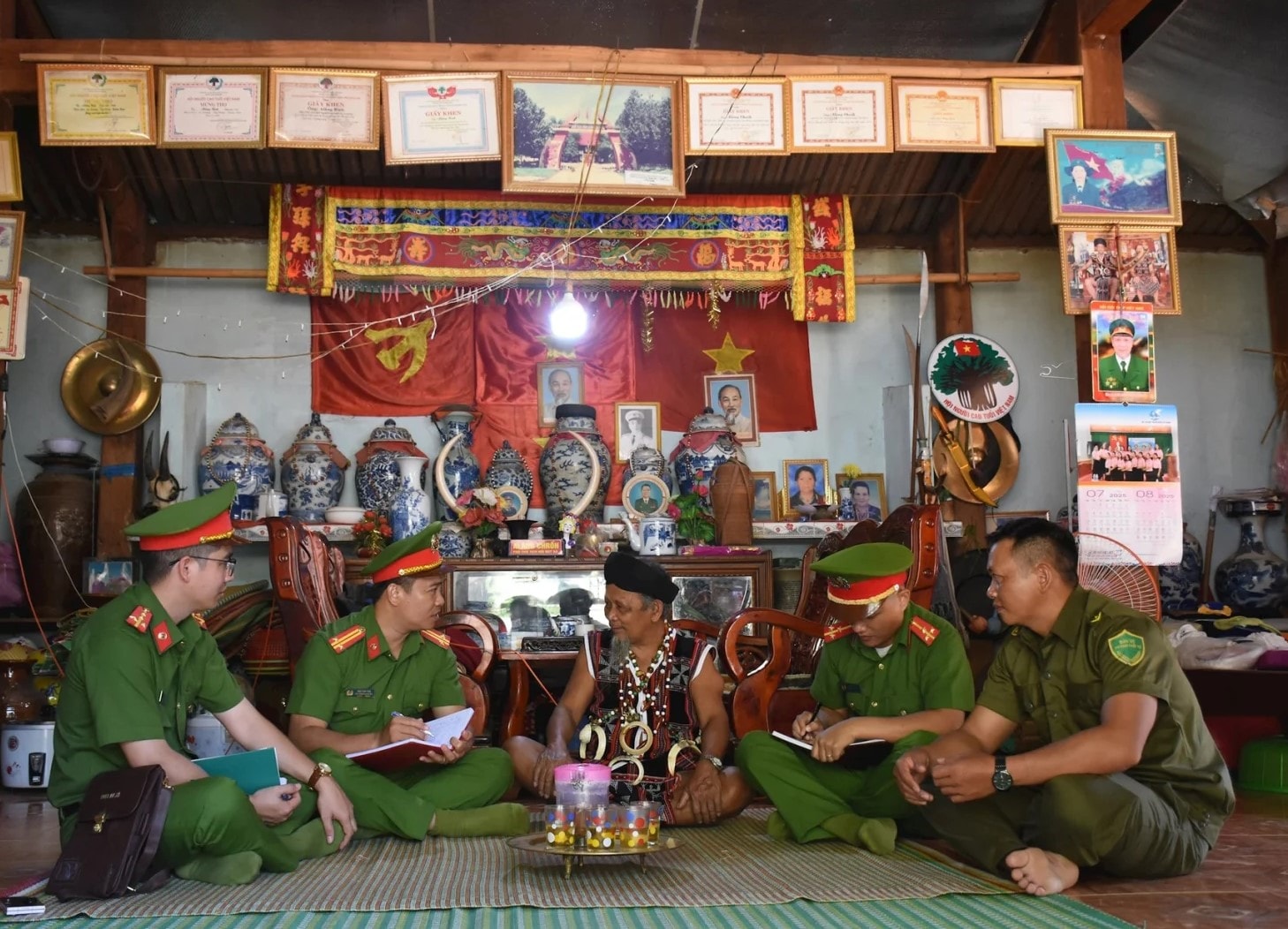 Cán bộ, chiến sĩ Công an xã A Vương và lực lượng tham gia bảo vệ an ninh ở cơ sở trao đổi công việc với người có uy tín trên địa bàn. Ảnh L.H 