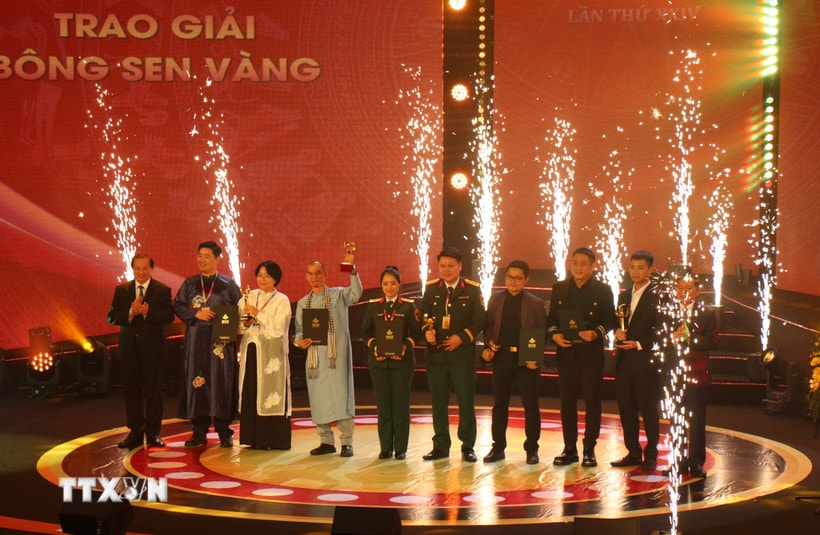 Thứ trưởng Bộ Văn hóa, Thể thao và Du lịch Tạ Quang Đông và Phó Trưởng ban Thường trực Ban Tuyên giáo và Dân vận Trung ương Lại Xuân Môn trao giải thưởng Bông sen Vàng. (Ảnh: Thu Hương/TTXVN)