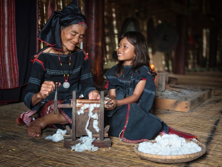 Người bà chỉ cho cô cháu nhỏ cách xử lý sợi bông. Ảnh: Ngô Trần Hải An.