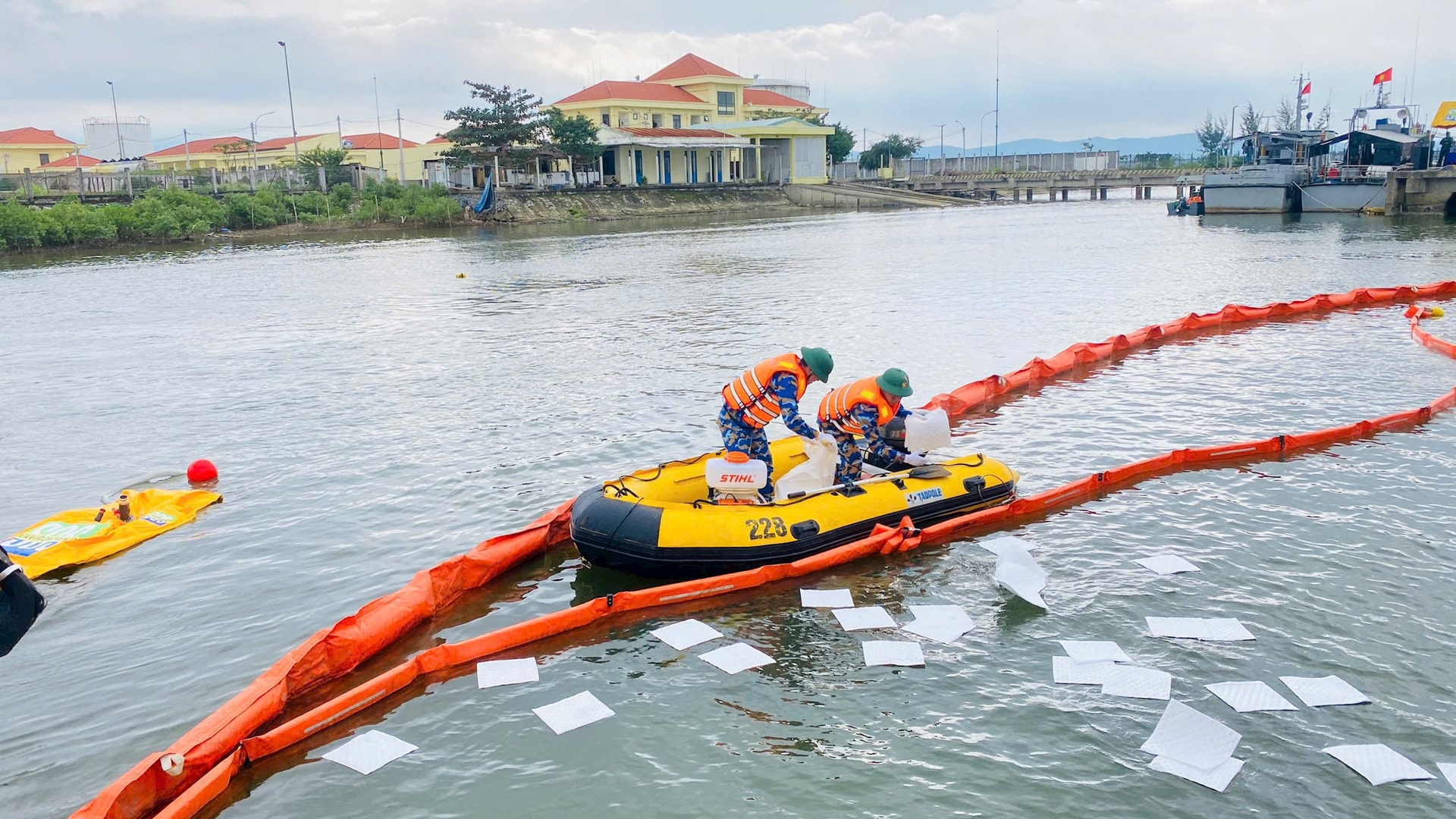 Vớt váng dầu bằng giấy chuyên dụng. Ảnh: HỒNG ANH