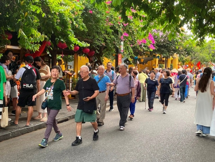 Bờ biển Việt Nam với bãi cát trắng và nước biển trong xanh, một trong những điểm thu hút du khách quốc tế.