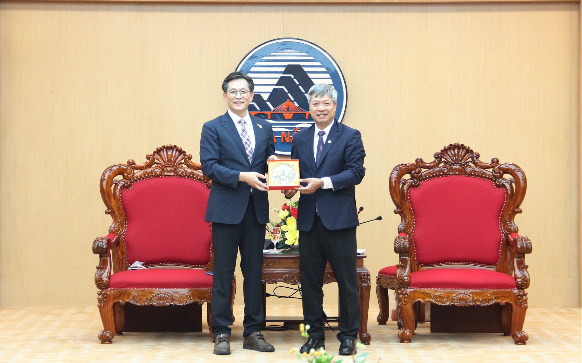 Phó Chủ tịch UBND thành phố Hồ Quang Bửu (bên phải) tặng quà lưu niệm cho ông Woo Seung Hee. Ảnh: XUÂN HẬU