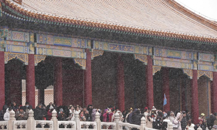 Du khách mặc trang phục cổ trang chụp ảnh trong Tử Cấm Thành phủ tuyết.