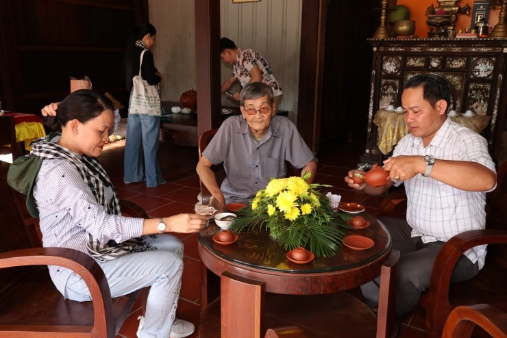 Chủ nhà mời trà tiếp các vị khách đến thăm.