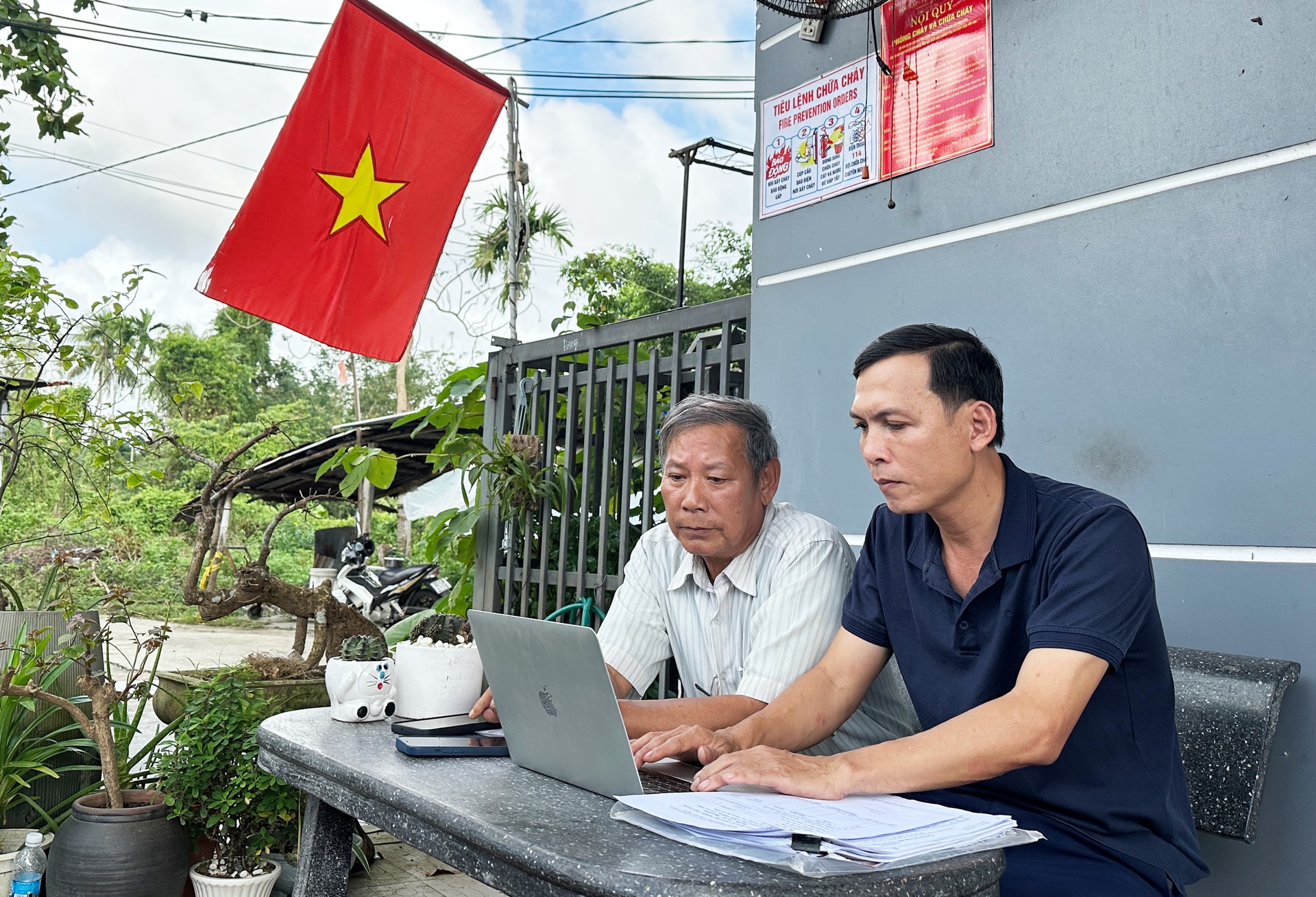 Ông Bùi Đình Thắng, Bí thư Chi bộ kiêm Trưởng ban công tác Mặt trận (bên trái) tìm hiểu về cách sử dụng phần mềm trí tuệ nhân tạo