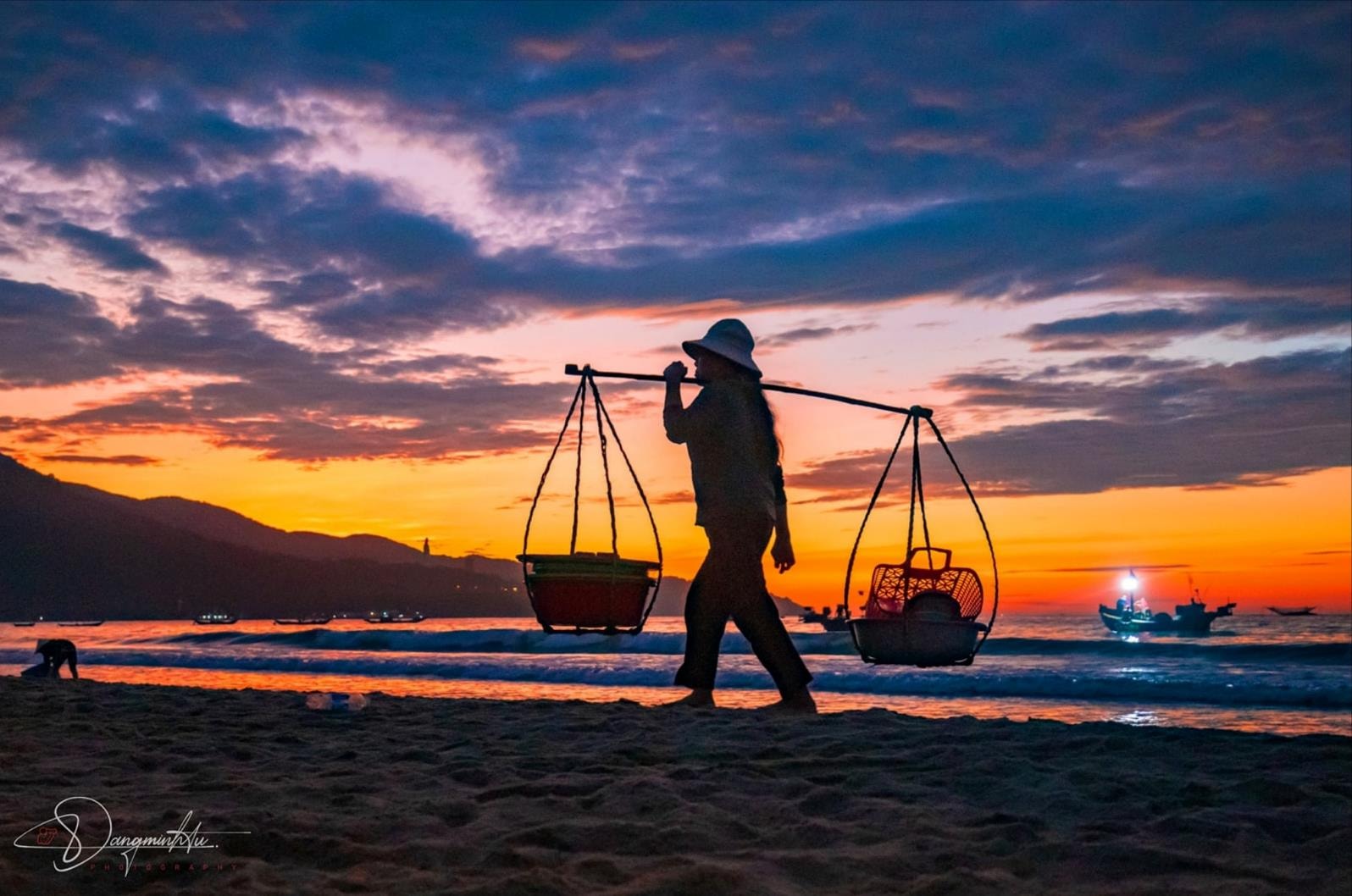 Ngư dân gánh thúng cá trở về khi trời vừa hửng sáng, mở đầu một ngày mưu sinh. Ảnh: ĐẶNG MINH TÚ