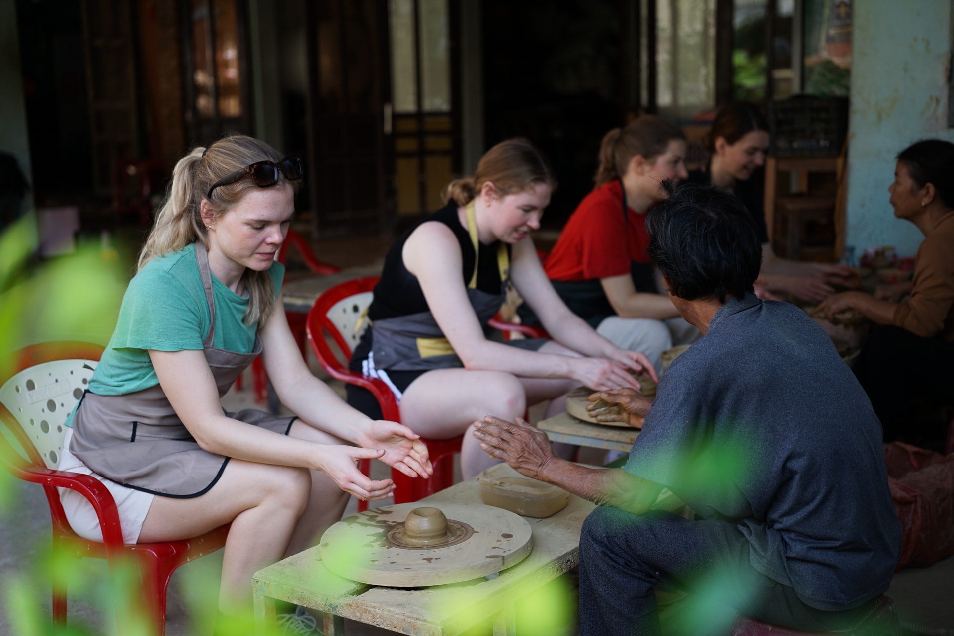 Ausländische Touristen erleben im Jahr 2026 im Töpferdorf Thanh Ha die Töpferkunst gemeinsam mit Kunsthandwerkern. Foto: Xuan So