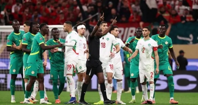 Các cầu thủ Senegal vây quanh trọng tài để phản đối quyết định thổi phạt đền.